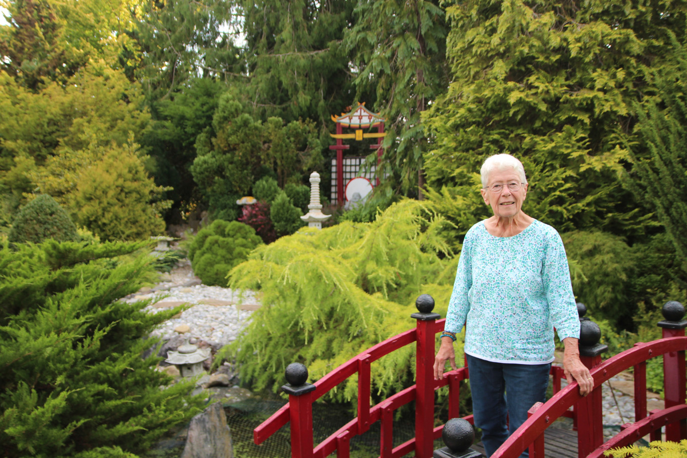 Louisette Piteau, sur le petit pont construit par son mari au cœur du jardin japonais. Celui-ci a été pensé autour d’une rivière sèche symbolisant le cours de la vie. ©Aletheia Press/ B.Delabre