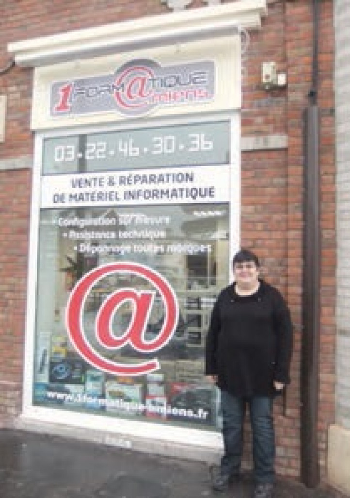 Cathy pose fièrement devant la vitrine d’un magasin qui prend de l’importance