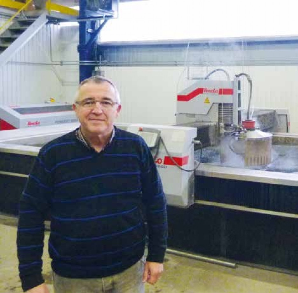 Marc Gense devant sa machine découpe jet eau 3D.