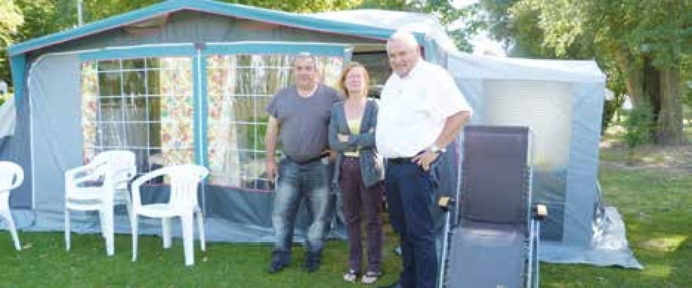 Jean-Pierre Leroux de la CCI (à d.) discute avec un couple de vacanciers venu du Nord.